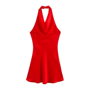 Macro detail of the bright red satin dress featuring a halter neck and sleek button closure