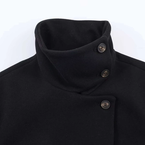 Detail shot of black wool jacket with stand collar and marble texture buttons
