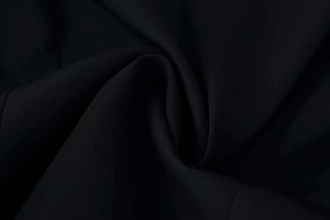 Close-up of black textile fabric showing fine grain texture and elegant drape detail