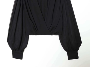 Detail of cross V-neck blouse with sheer lantern sleeves and pleated waist design