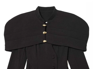 Detail of structured blazer with cape overlay and teardrop golden metal buttons