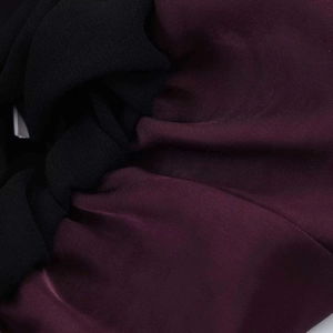 Detail shot of the purple and black fabric texture with pleated chiffon ruffles