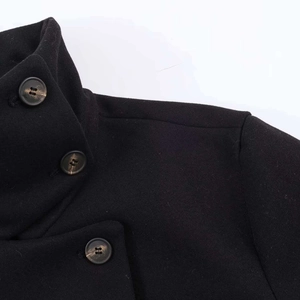 Close-up of a black wool short jacket featuring a stand collar and marble buttons