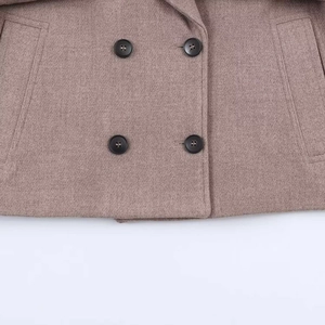 Detail of double-breasted dusty pink wool jacket with textured fabric and dark buttons