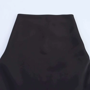 Close-up of minimalist black high-waisted dress waistline showing smooth fabric texture