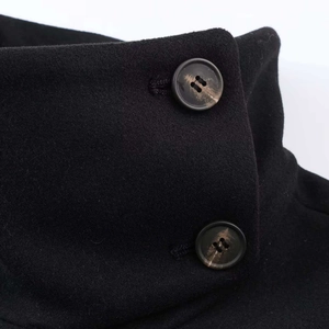 Close-up of black wool jacket featuring a high stand collar and textured buttons