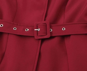 Dettaglio della cintura di un blazer bordeaux con occhielli argentati e fibbia in tessuto
