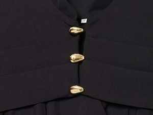 Close-up of black blazer neckline with elegant gold teardrop buttons and size label