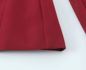 Macro del tessuto bordeaux della giacca con trama fitta e cuciture precise dell'orlo