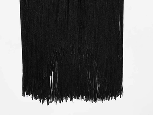 Detail showing the dense vertical black fringe tassels with smooth texture and drape