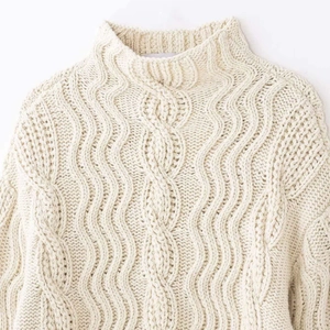 Cozy cream white cable knit turtleneck sweater with thick textured patterns