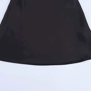 Detail of the hemline on a black sleeveless dress showing high-quality stitching and fabric