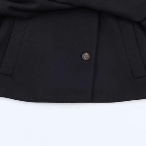 Detail view of woven fabric texture with marble pattern button on black cropped jacket