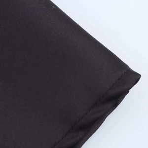 Detailed close-up showing the precise stitching and smooth black fabric on the dress hem