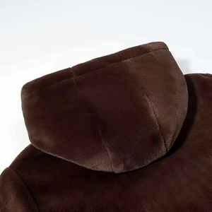 Close-up of soft brown faux fur texture and hood stitching on a warm plush jacket