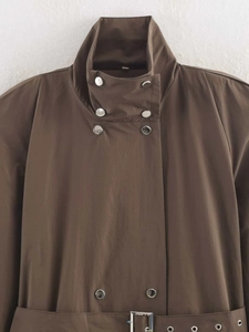 Detail of a brown trench coat collar with silver snap buttons and a matching belted waist