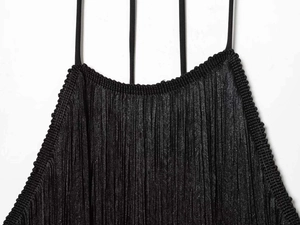 Detailed view of black pleated fabric texture and triple shoulder straps on the neckline