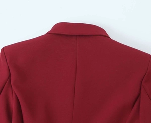 Dettaglio dello scollo del blazer bordeaux che mostra il tessuto in saia e le cuciture