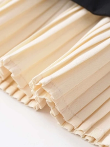 Macro detail of creamy off-white pleated fabric with fine stitching and black trim