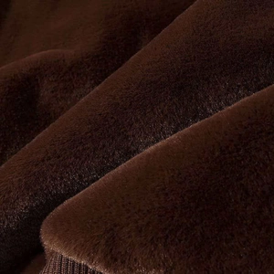 Macro shot of dark brown plush faux fur fabric with ribbed knit hem finish detail