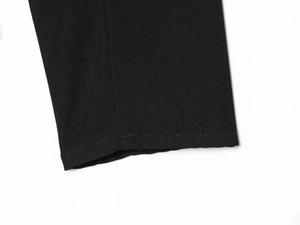 Close-up of black blazer cuff showing premium twill fabric texture and clean stitching