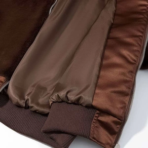 Detail of dark brown jacket featuring fleece lining, satin sleeve interior, and ribbed hem