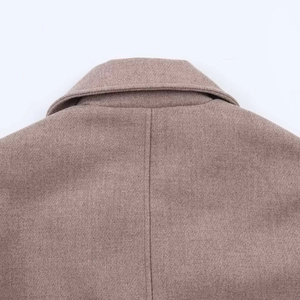 Detailed close-up of brown wool jacket showing precise collar stitching and twill texture