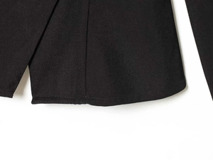 Macro shot of the black blazer hem featuring premium diagonal twill texture and stitching