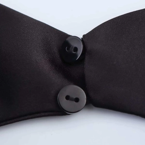 Close-up of black satin dress fabric featuring smooth texture and round button detail