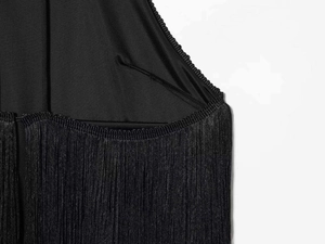 Detail shot of the black halter dress featuring high-quality fringe and fine stitching