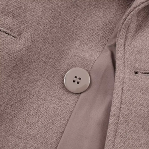 Macro detail of coffee wool blend fabric with color-matched button and silk lining