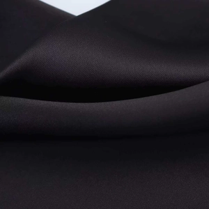 Macro shot of high-quality black silk-satin fabric showing smooth texture and soft folds