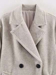 Detailed close-up of light grey wool coat lapels with smooth inner lining texture
