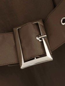 Detail of a dark brown trench coat waist belt with silver metal buckle and eyelets