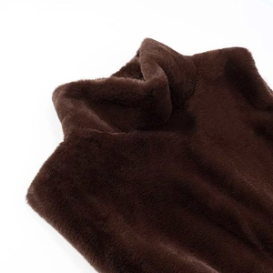 Détail du tissu en peluche marron foncé sur un gilet ajusté à col montant élégant