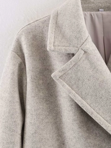 Detail of wool blend coat collar showing grey melange texture and satin lining