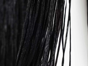 Detailed macro view of shimmering black fringe texture on a halter neck dress