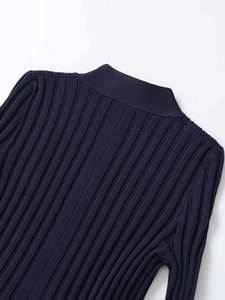 Nahaufnahme der gerippten Strickstruktur und des V-Ausschnitts am dunkelblauen Strickjacke