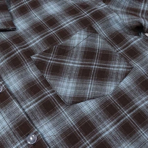 Detail of vintage plaid shirt showing chest pocket and precise button alignment