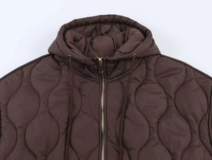 Détail de la capuche de veste matelassée marron avec fermeture éclair dorée chic