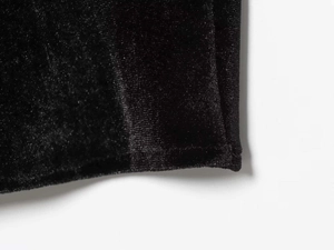 Detailed close-up of premium black velvet fabric texture and fine stitching craftsmanship