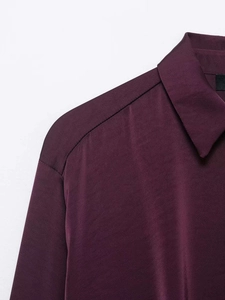 Detail shot of vintage burgundy satin shirt collar showing smooth silky texture