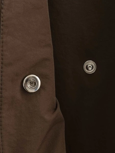 Detail view of silver metal snap buttons and high-quality brown trench coat fabric texture