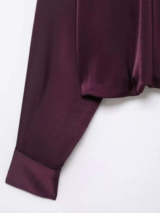 Detailed close-up showing the smooth satin texture and sleek cuffs of the burgundy shirt