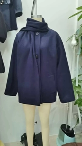 Close-up of dark blue wool blend coat featuring unique integrated scarf collar detail