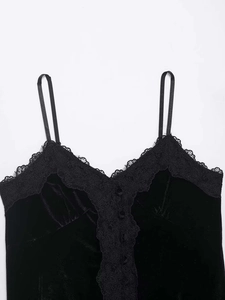 Détail du caraco en velours noir avec bordure en dentelle et boutons en tissu