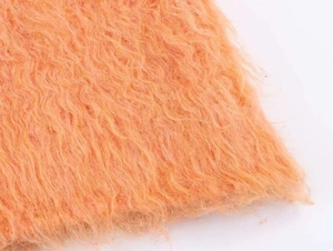 Gros plan détaillé sur la fourrure synthétique orange vif à longs poils bouclés