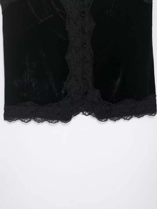 Détails rapprochés d'un débardeur en velours noir avec dentelle et boutons élégants