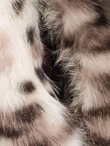Gros plan sur la texture de fausse fourrure épaisse à imprimé léopard blanc et gris