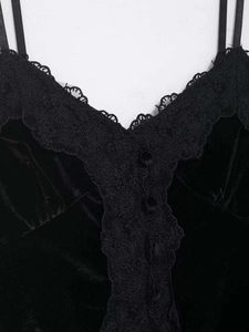 Détail de la dentelle en V et des boutons décoratifs sur un débardeur en velours noir